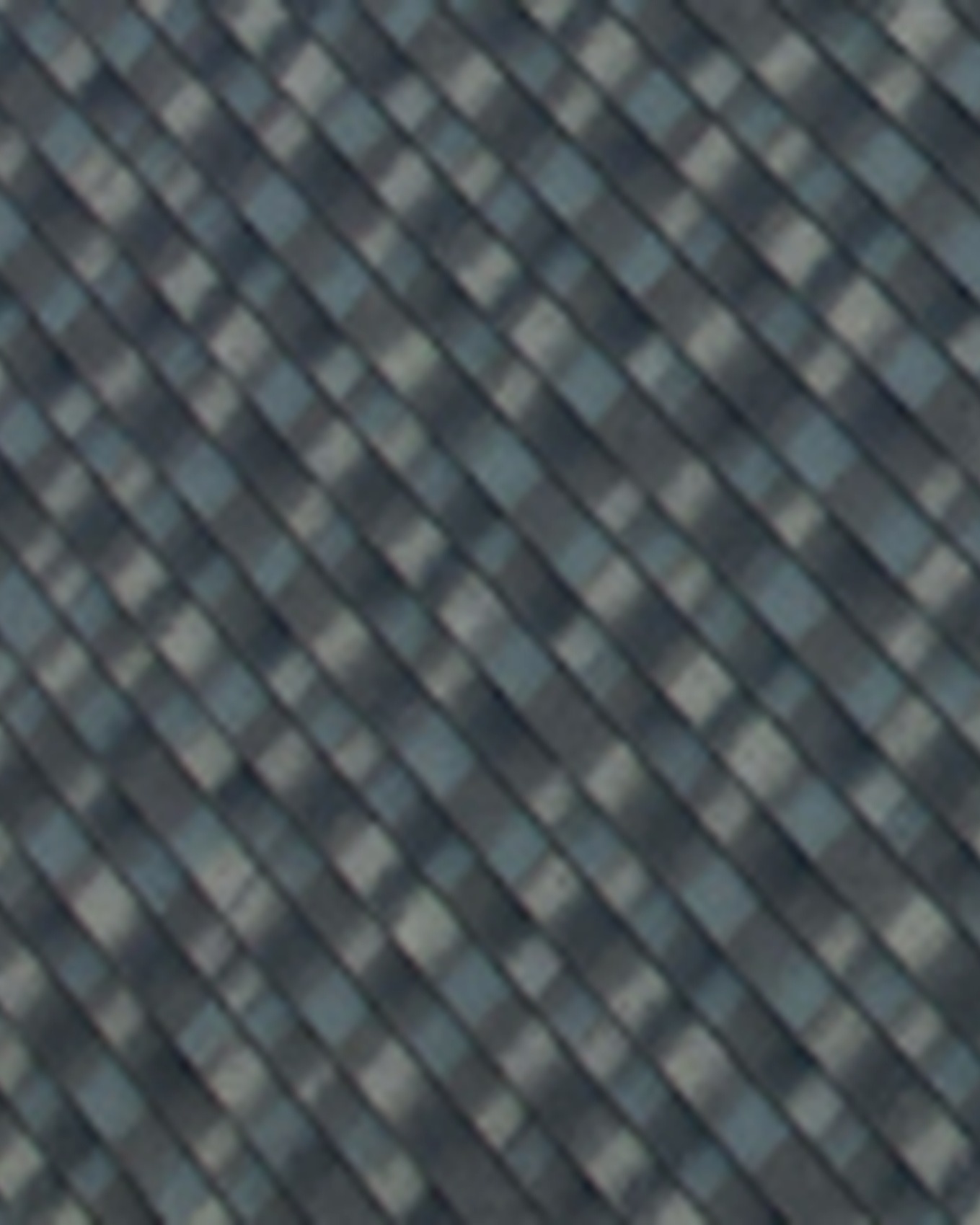 Close-up of DECRA Shingle XD flat stepped interlocking dark charcoal stone-coated metal panel resembling premium multi-layered architectural asphalt shingle